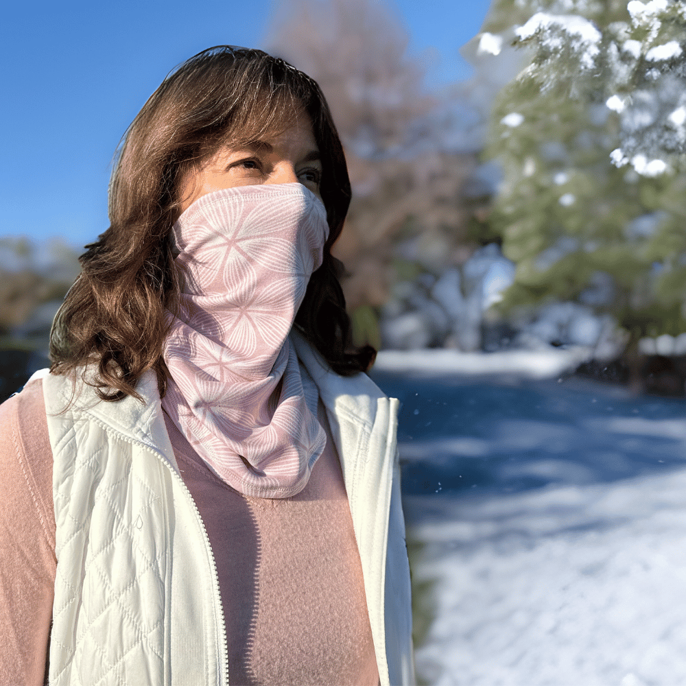 Woman wearing Snow Petal cozy wrap in pink and white and pulled up from neck around nose and mouth.