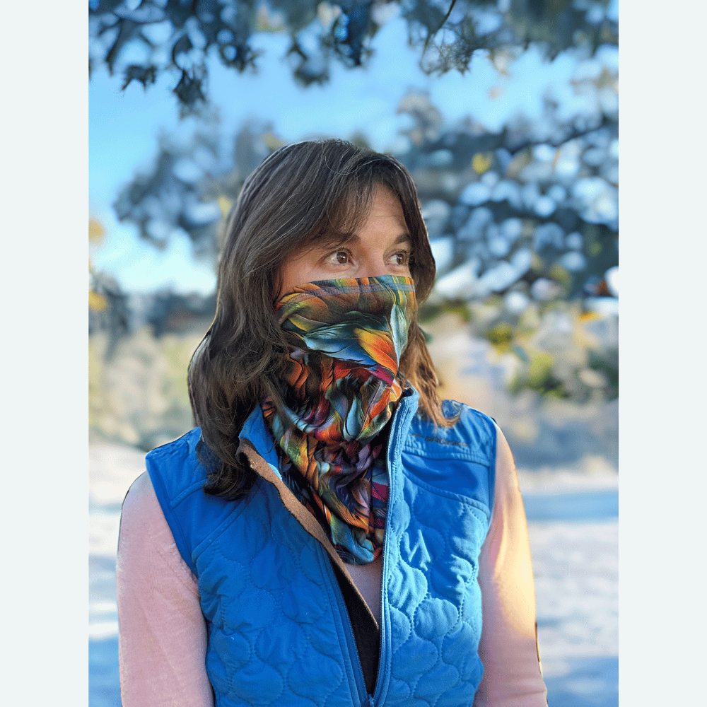 Woman wearing plumes cozy wrap around neck and pulled up over nose and mouth.