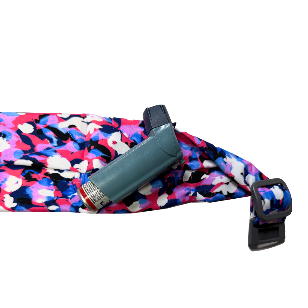 close up showing an asthma inhaler on a patterned belt on a white background