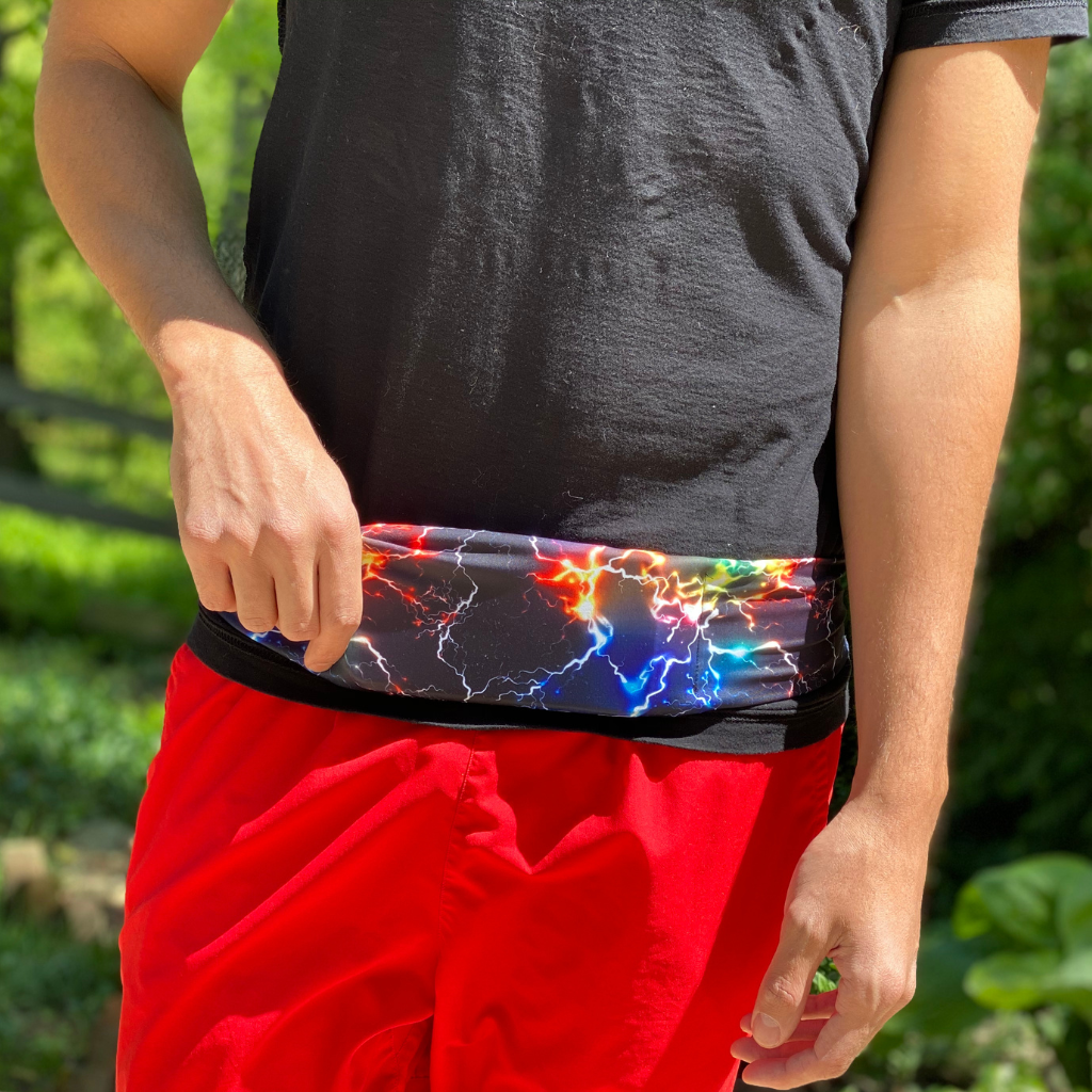 Man wearing BANDI Cosmic Belt. He has on Red shorts and black T shirt. the belt is colorful and looks like electricity.