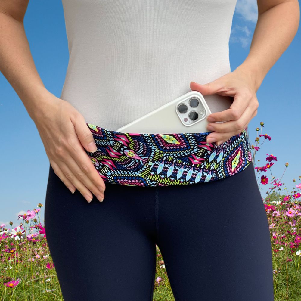 woman wearing pocketed belt around waist with phone jewel tones geometric.
