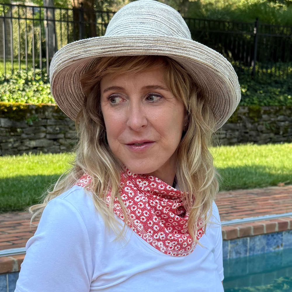 Woman wearing a BANDI  orangey red floral sun wrap by a pool